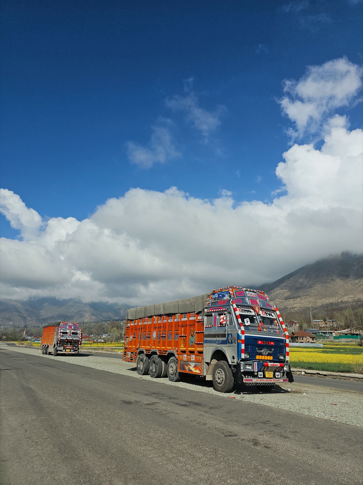 Goods trucks on a mountain highway under a blue sky